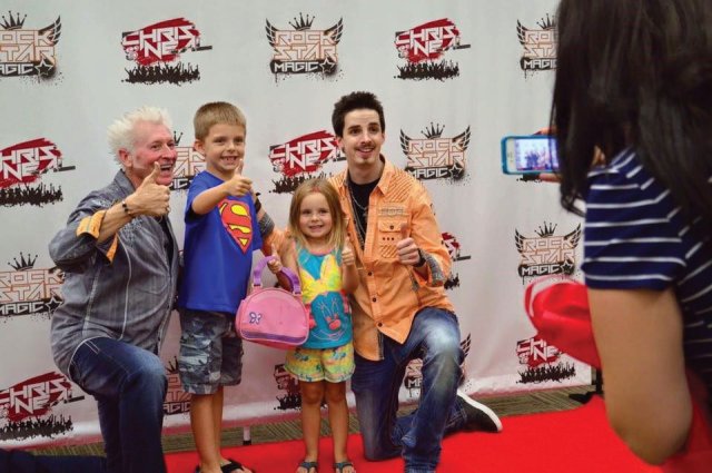Children take their photos on the red carpet with Jacksonville magicians Chris and Neal from Rockstar Magic