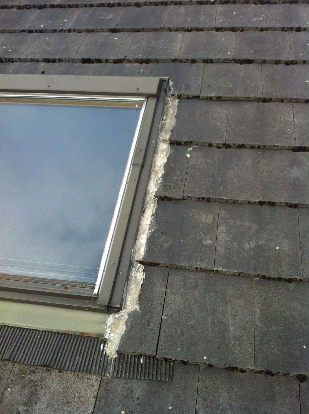 Velux windows come with a flashing that is designed to keep rain and snow out safely. Blocking these with mortar will only lead to further problems.