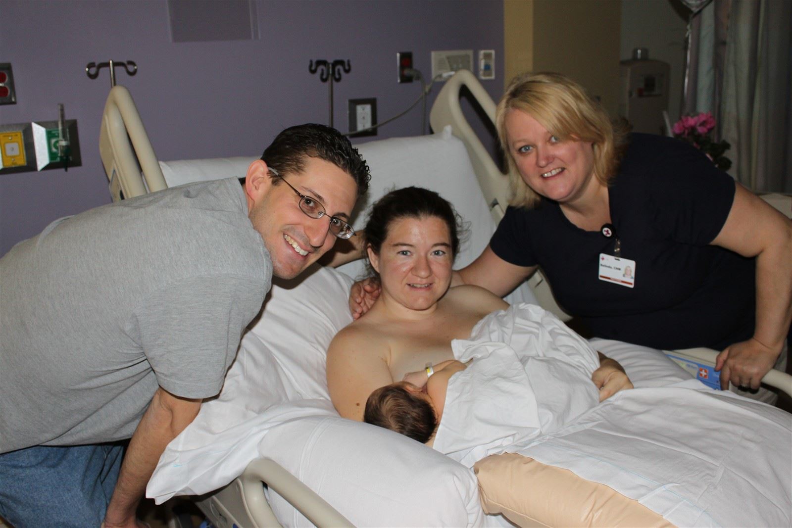 30 hours old : Baby Madeline is nursing contentedly at the breast after her labor and delivery - Erica showing how skin-to-skin is best for establishing the nursing relationship.  Pictured here with Coach Mike and the amazing Belinda Hodder, CNM from Valley Women for Women.  We love her!!